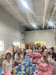 The Monthlies Project "Regs" packing 2025 summer kits for local schools and organizations